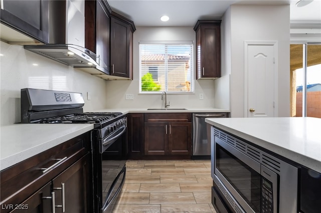 5940 Tamarack Lodge Ln, North Las Vegas, NV 89081 - kitchen featuring light countertops, dark brown cabinets, a sink, wall chimney exhaust hood, and appliances with stainless steel finishes