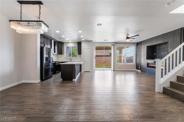 5940 Tamarack Lodge Ln, North Las Vegas, NV 89081 - kitchen featuring a center island, stainless steel fridge with ice dispenser, open floor plan, and ceiling fan with notable chandelier