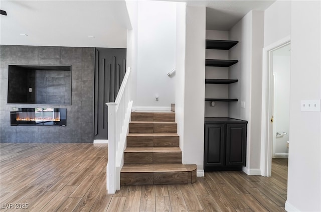 5940 Tamarack Lodge Ln, North Las Vegas, NV 89081 - staircase with baseboards, a tiled fireplace, and wood finished floors