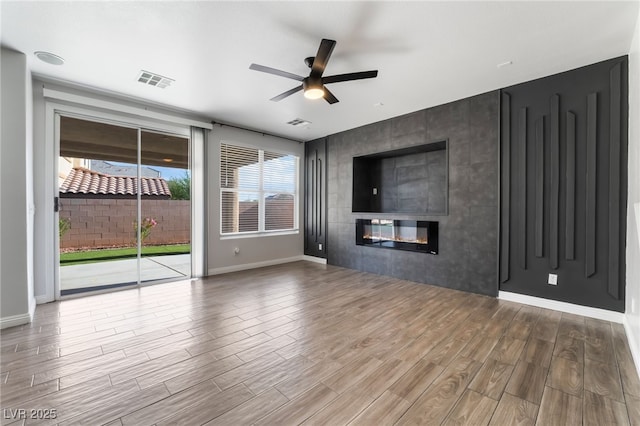 5940 Tamarack Lodge Ln, North Las Vegas, NV 89081 - unfurnished living room featuring a ceiling fan, wood finished floors, visible vents, and a healthy amount of sunlight