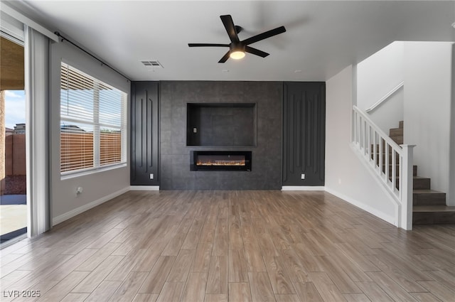 5940 Tamarack Lodge Ln, North Las Vegas, NV 89081 - unfurnished living room with ceiling fan, wood finished floors, and stairs