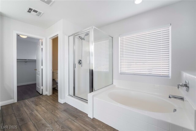 5940 Tamarack Lodge Ln, North Las Vegas, NV 89081 - full bath with wood finished floors, a stall shower, a bath, toilet, and visible vents
