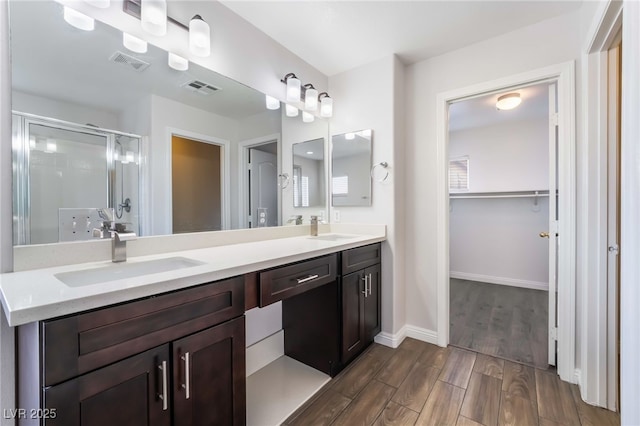 5940 Tamarack Lodge Ln, North Las Vegas, NV 89081 - bathroom with a shower stall, wood finished floors, a sink, and visible vents