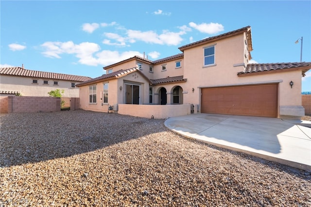 5940 Tamarack Lodge Ln, North Las Vegas, NV 89081 - view of front facade featuring a tile roof, driveway, fence, a garage, and stucco siding