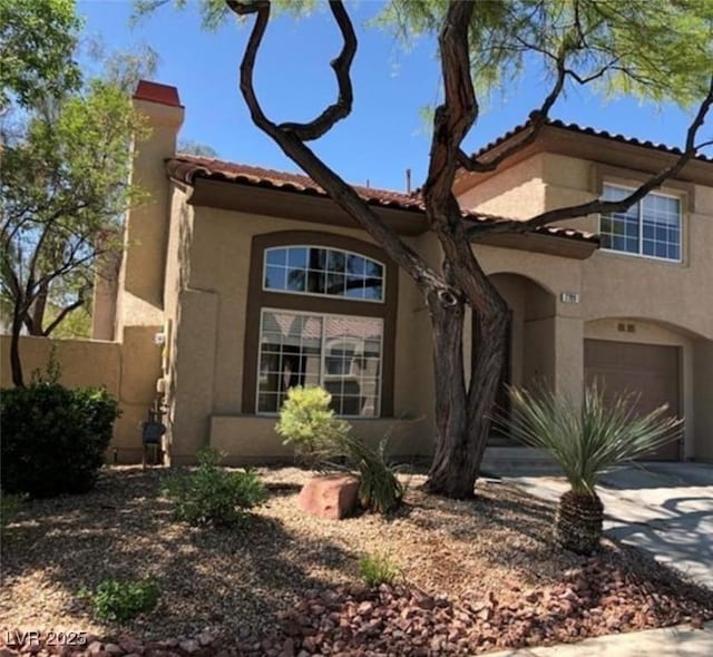 7709 Bauble Ave, Las Vegas, NV 89128 - mediterranean / spanish house featuring a tiled roof, an attached garage, a chimney, concrete driveway, and stucco siding