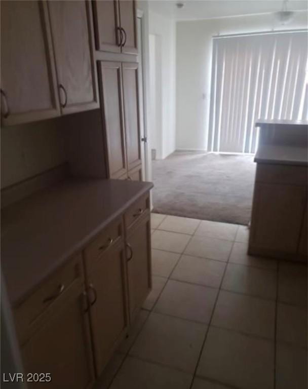 7709 Bauble Ave, Las Vegas, NV 89128 - kitchen featuring light colored carpet, light countertops, and light tile patterned floors