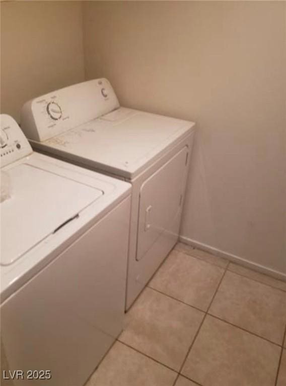7709 Bauble Ave, Las Vegas, NV 89128 - clothes washing area featuring washer and dryer, light tile patterned floors, laundry area, and baseboards