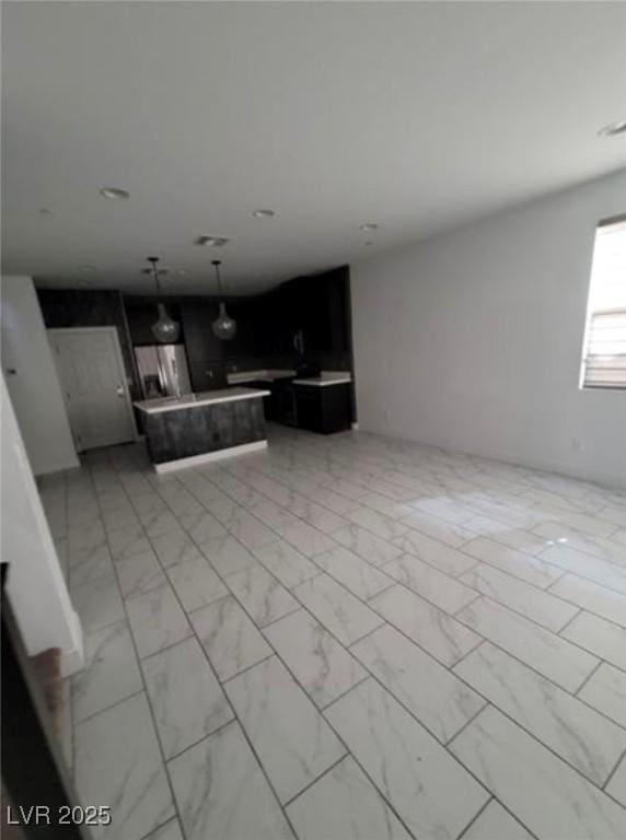 kitchen with a center island, marble finish floor, light countertops, hanging light fixtures, and open floor plan