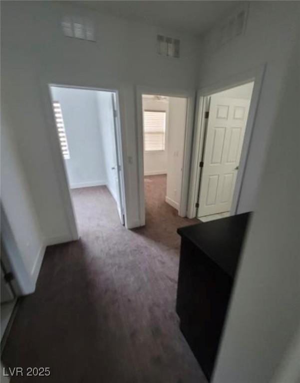 hallway with carpet flooring and baseboards