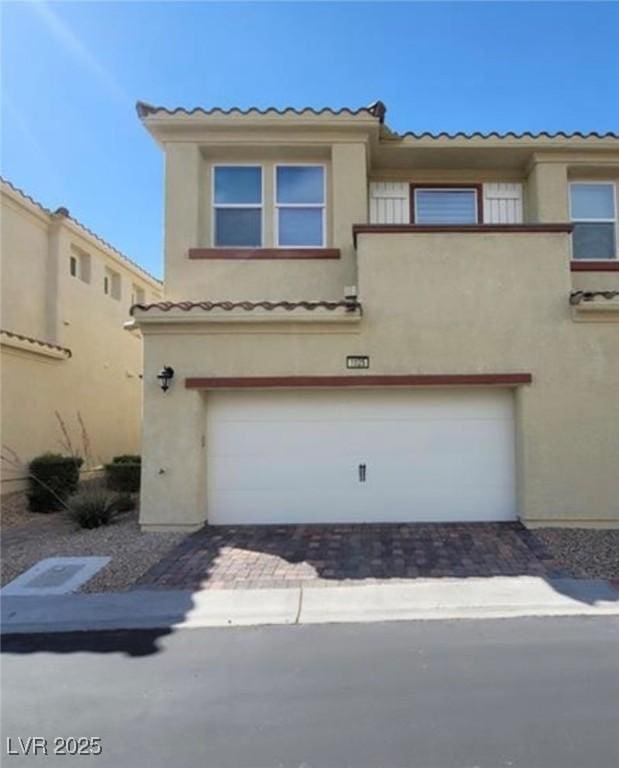 view of front of property featuring an attached garage, driveway, and stucco siding