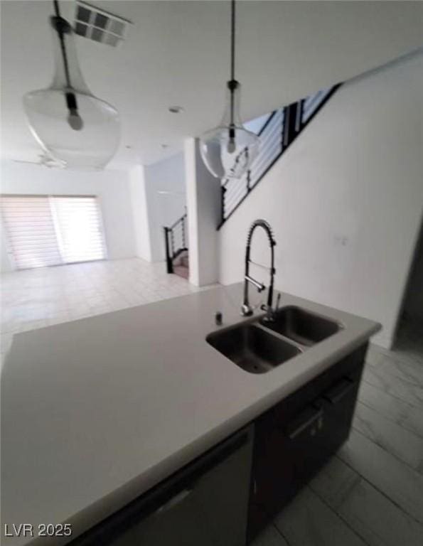 kitchen with decorative light fixtures, visible vents, and a sink