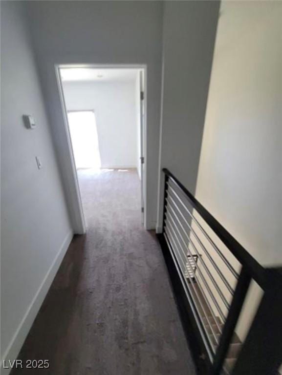 hall featuring baseboards and carpet