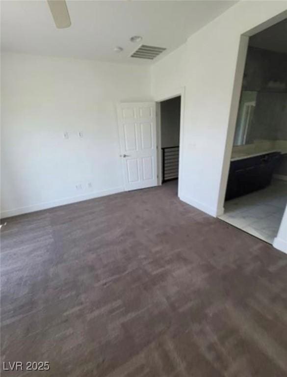unfurnished bedroom with visible vents, baseboards, a ceiling fan, and ensuite bath