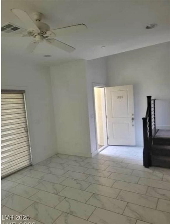 empty room with visible vents, ceiling fan, and marble finish floor
