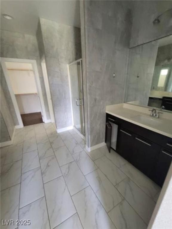 bathroom with a stall shower, marble finish floor, and vanity