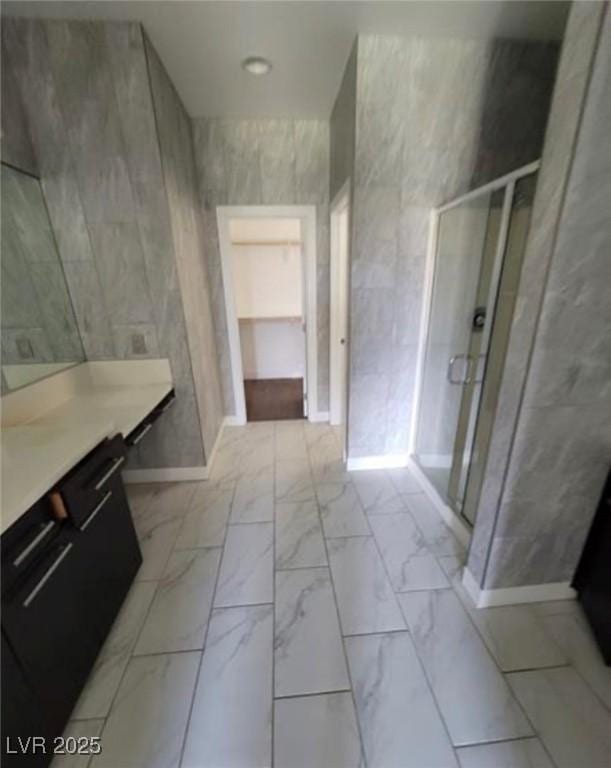 full bathroom with a shower stall, vanity, marble finish floor, and baseboards
