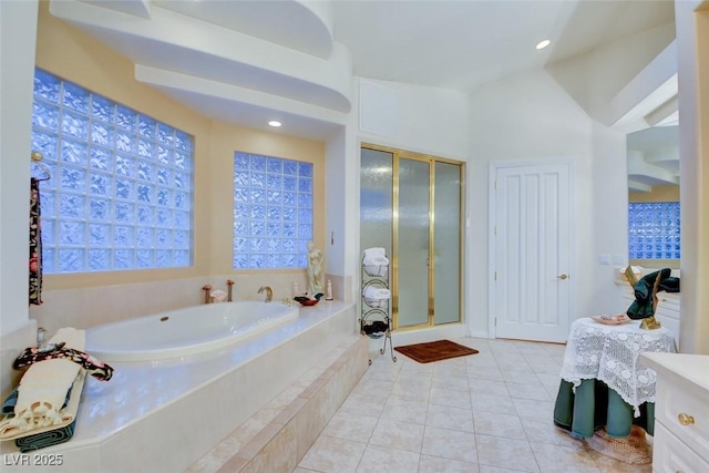 full bathroom featuring tile patterned flooring, a garden tub, and a stall shower
