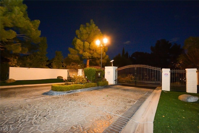 gate at night featuring fence