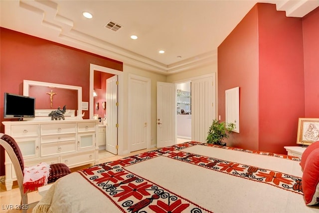 bedroom with connected bathroom, recessed lighting, and visible vents