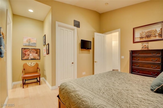 bedroom with baseboards, recessed lighting, and light wood-style flooring