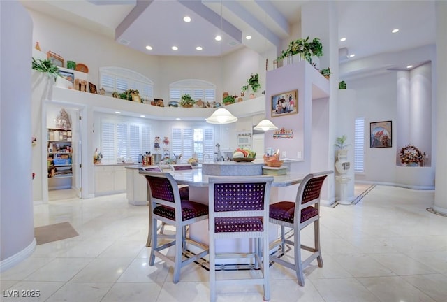 dining room with baseboards, recessed lighting, a high ceiling, and light tile patterned floors