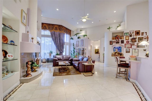 living area with a ceiling fan, a high ceiling, recessed lighting, and light tile patterned floors