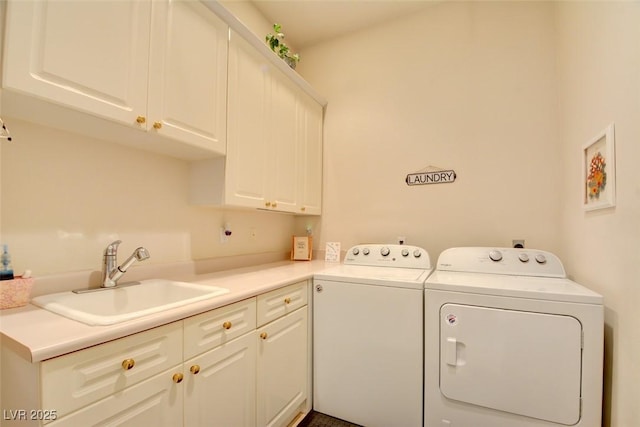clothes washing area featuring a sink, separate washer and dryer, and cabinet space