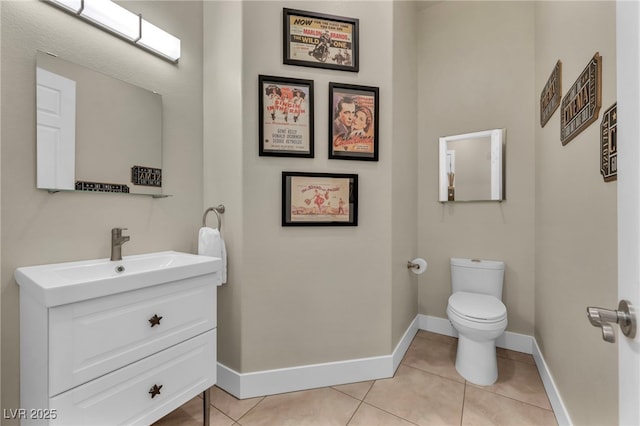 bathroom with tile patterned flooring, vanity, baseboards, and toilet