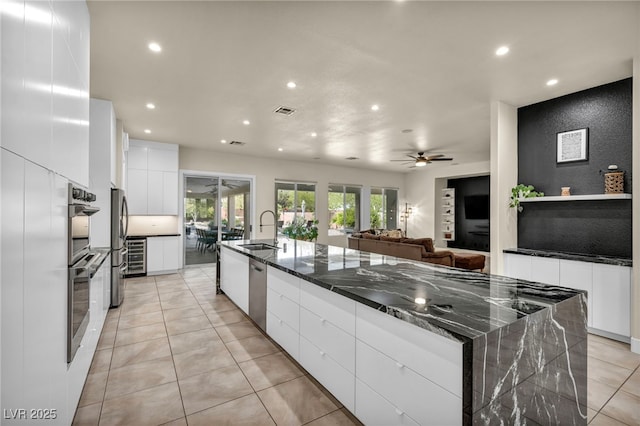 kitchen featuring a ceiling fan, appliances with stainless steel finishes, a sink, and modern cabinets