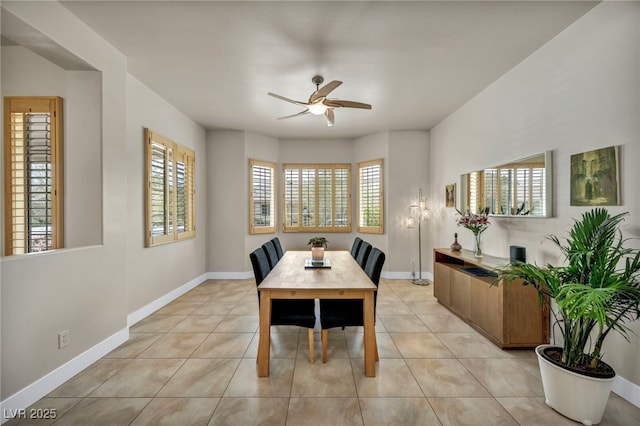 dining area with light tile patterned floors, baseboards, and a ceiling fan