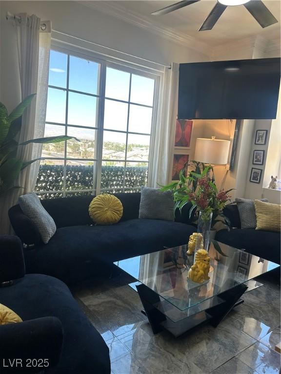 living room featuring a wealth of natural light, marble finish floor, crown molding, and ceiling fan
