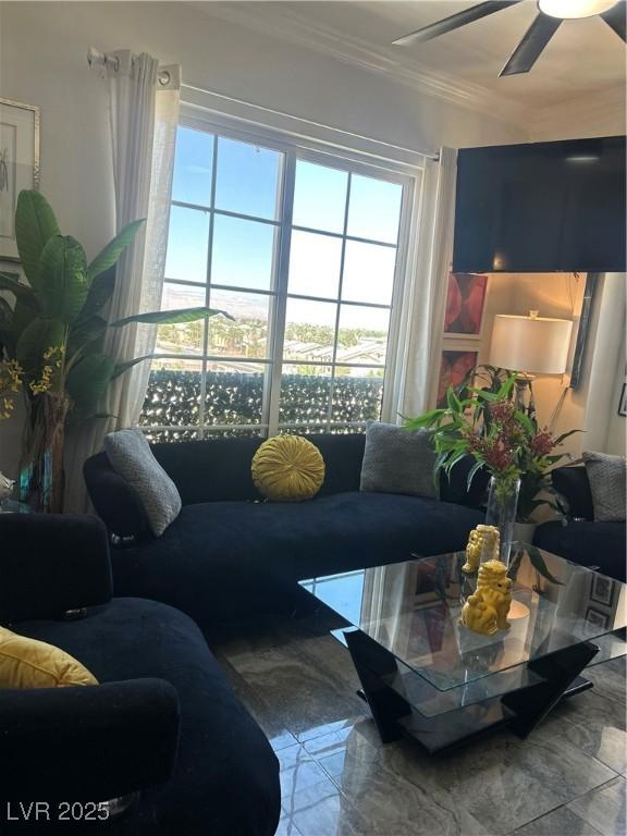 living room with crown molding and a ceiling fan