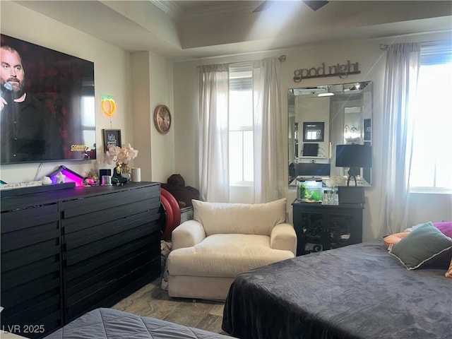 bedroom featuring wood finished floors, crown molding, and multiple windows