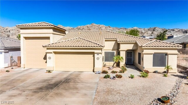 view of front facade with an attached garage, a tiled roof, driveway, and stucco siding