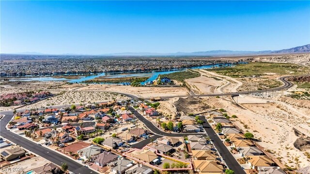 drone / aerial view featuring a water and mountain view and a residential view
