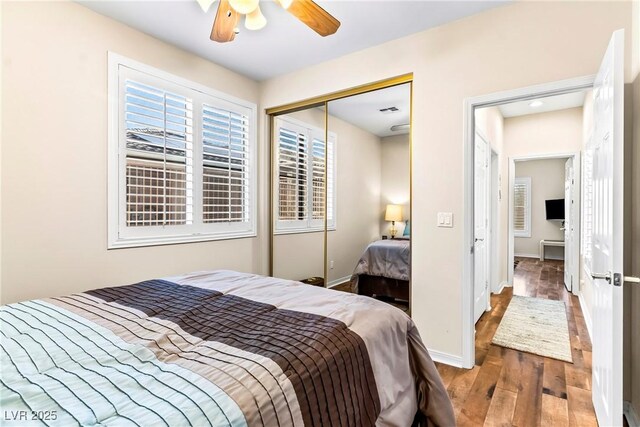 bedroom with ceiling fan, baseboards, wood finished floors, and a closet
