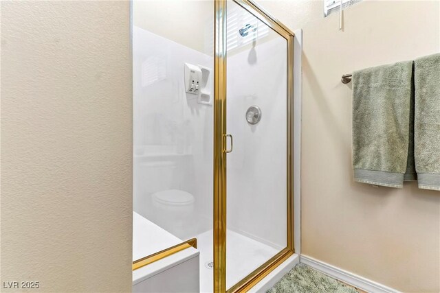 full bath with a shower stall and baseboards