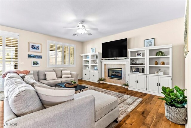 living area featuring dark wood-style floors, a fireplace, and ceiling fan