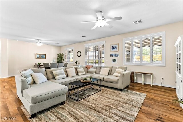 living area featuring ceiling fan, baseboards, wood finished floors, and visible vents
