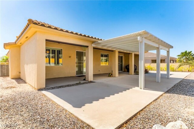 rear view of property with fence, a patio area, and stucco siding