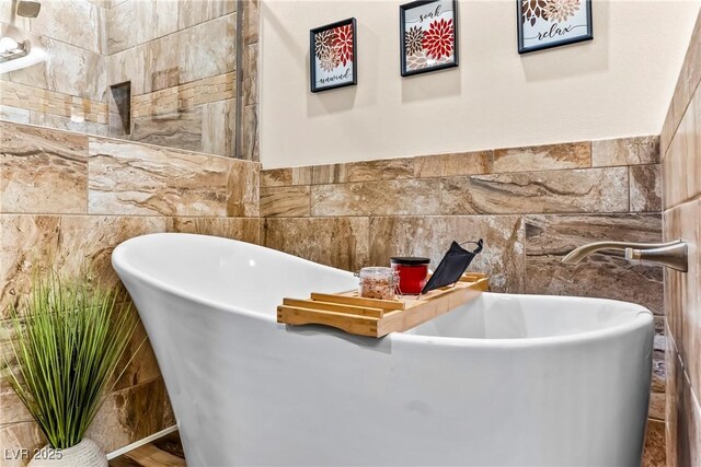 bathroom with a freestanding bath and tile walls