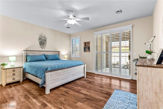 bedroom with baseboards, access to outside, wood finished floors, and visible vents