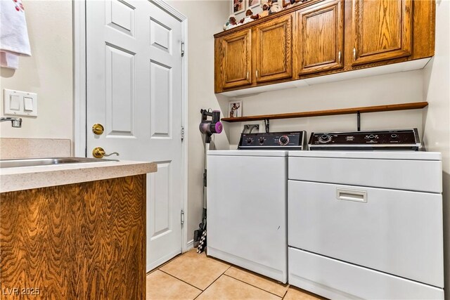 laundry area featuring separate washer and dryer, cabinet space, a sink, and light tile patterned floors