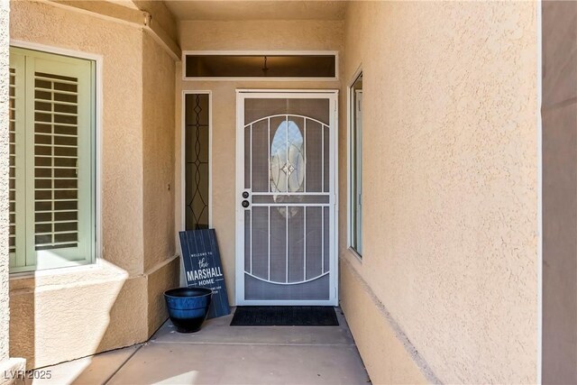 view of exterior entry with stucco siding