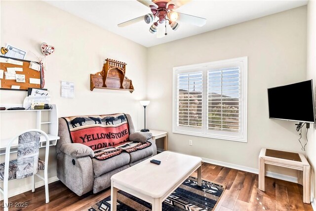 living room featuring baseboards, wood finished floors, and ceiling fan