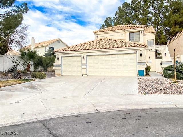 mediterranean / spanish home with a tiled roof, stucco siding, fence, an attached garage, and driveway