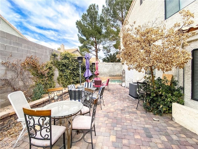 view of patio / terrace with central AC unit, a fenced backyard, and outdoor dining space