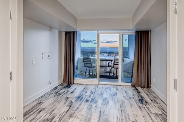 empty room with baseboards and wood finished floors