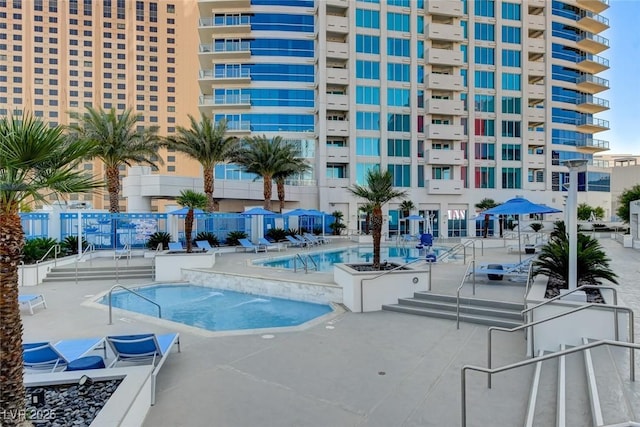 community pool with fence and a patio area