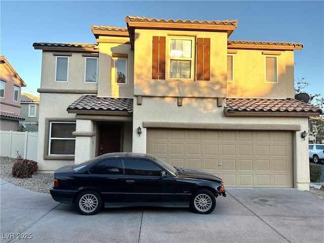 view of front of home with a tiled roof, a garage, stucco siding, fence, and concrete driveway